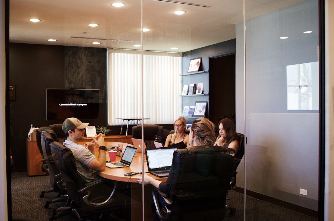 Business team collaborating around laptops in a meeting room
