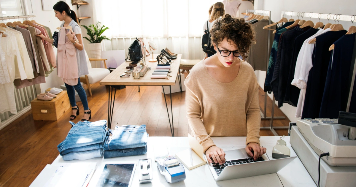 A cover blog image with two girls working at a small business, one on laptop